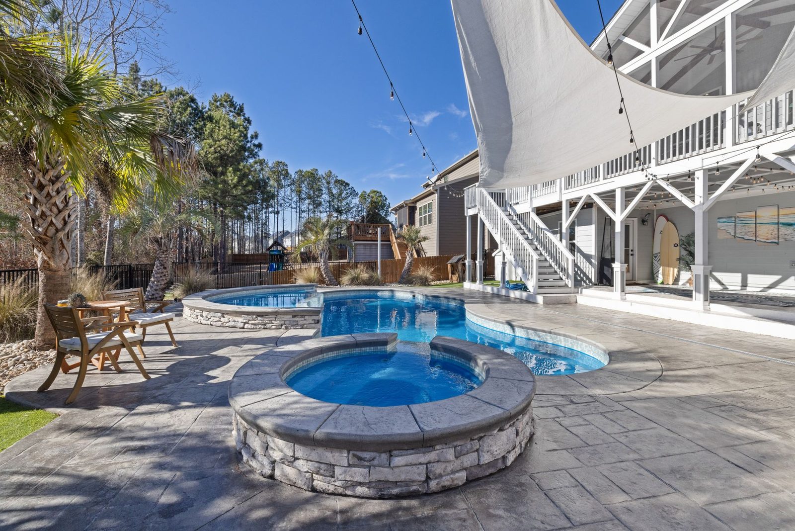 Freeform pool paired with a raised stone spa — design inspiration